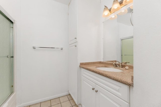 bathroom with tile patterned flooring, vanity, and bath / shower combo with glass door