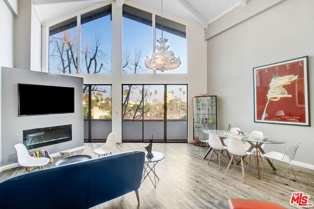 living room with hardwood / wood-style floors, a wealth of natural light, and high vaulted ceiling