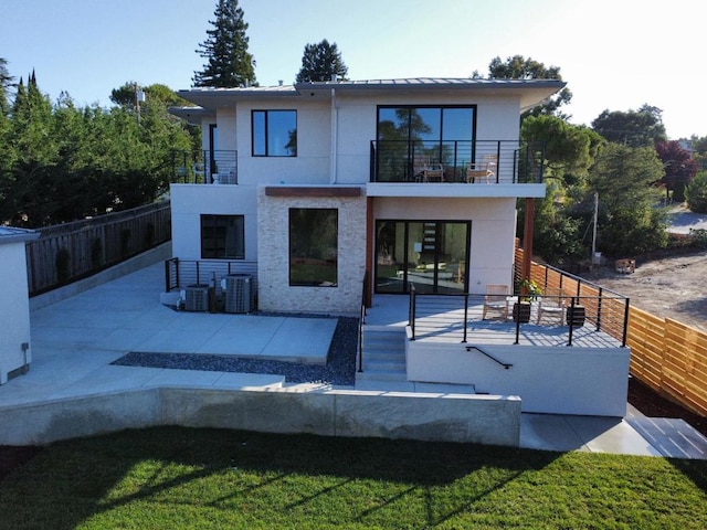 back of property featuring cooling unit, a balcony, and a patio area