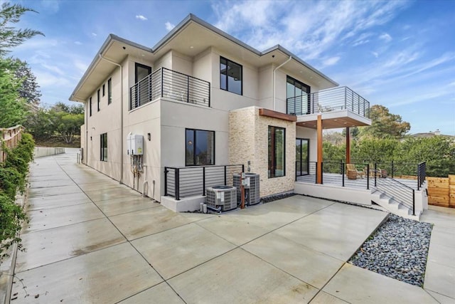 back of property featuring a balcony, central AC, and a patio area