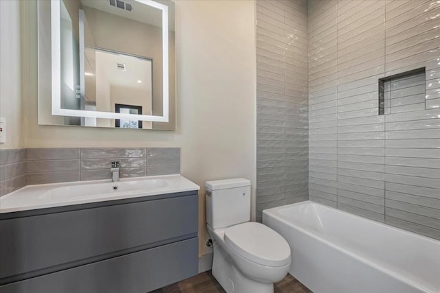 full bathroom with vanity, tiled shower / bath combo, and toilet