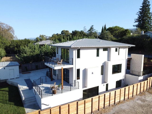 back of house featuring a shed, a patio area, and a balcony