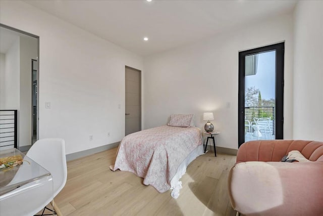 bedroom featuring light wood-type flooring and access to outside