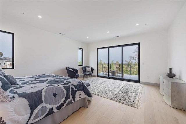 bedroom with multiple windows, access to outside, and light hardwood / wood-style flooring