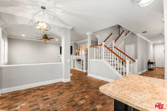 entrance foyer featuring decorative columns, crown molding, and ceiling fan