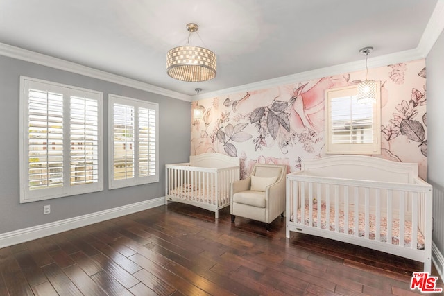 bedroom featuring a crib, ornamental molding, and dark wood-type flooring