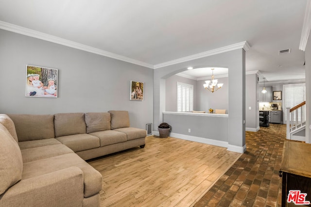 living room featuring hardwood / wood-style flooring, crown molding, and a notable chandelier