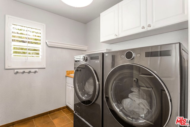 washroom featuring washer and clothes dryer, cabinets, and dark tile patterned floors