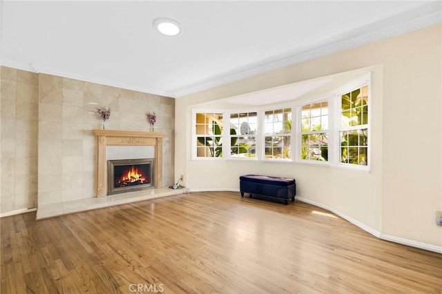 unfurnished living room featuring hardwood / wood-style flooring, a fireplace, and ornamental molding