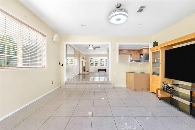 unfurnished living room with light tile patterned flooring and ceiling fan