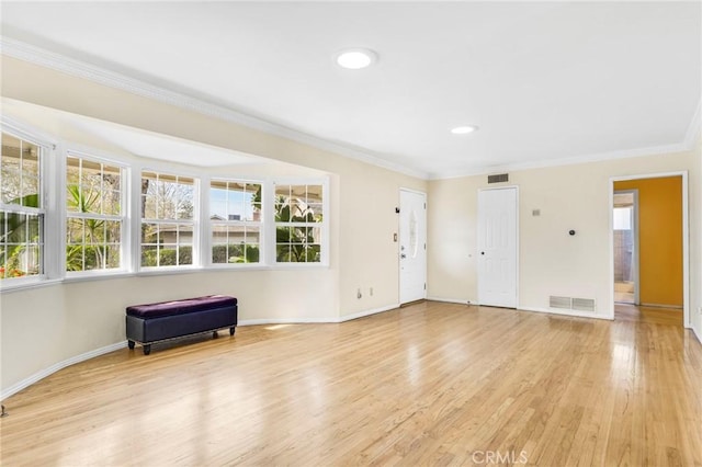 interior space with crown molding and light hardwood / wood-style flooring