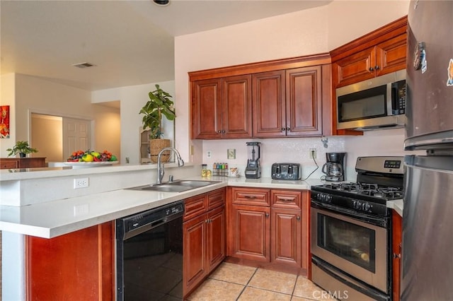 kitchen with light tile patterned flooring, appliances with stainless steel finishes, sink, and kitchen peninsula