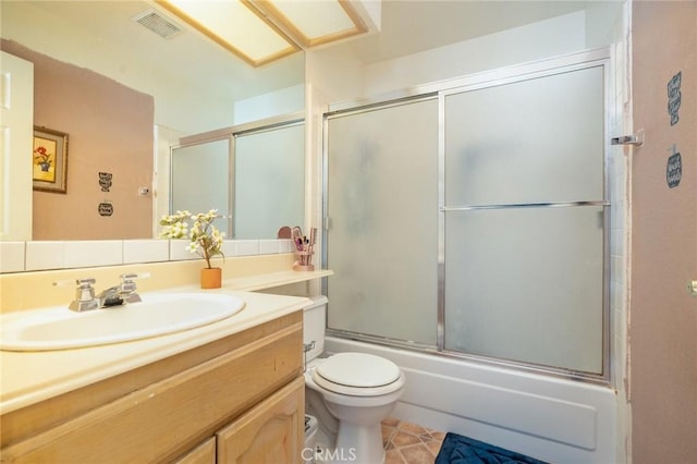 full bathroom with enclosed tub / shower combo, vanity, toilet, and tile patterned floors