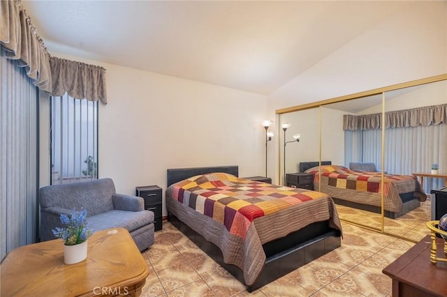 tiled bedroom featuring vaulted ceiling and a closet