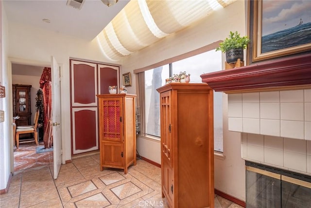 hall featuring light tile patterned floors