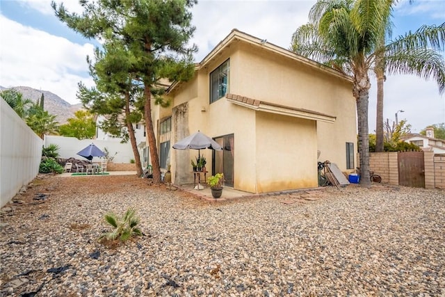 back of property with a patio and a mountain view