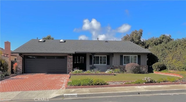 ranch-style home with a garage and a front lawn