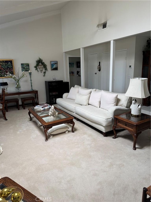 carpeted living room with high vaulted ceiling