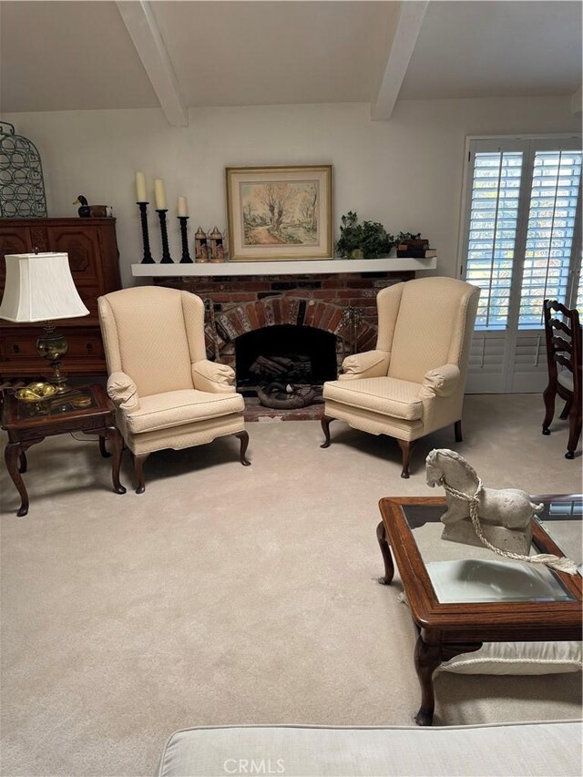 living area with a brick fireplace, light carpet, and beam ceiling