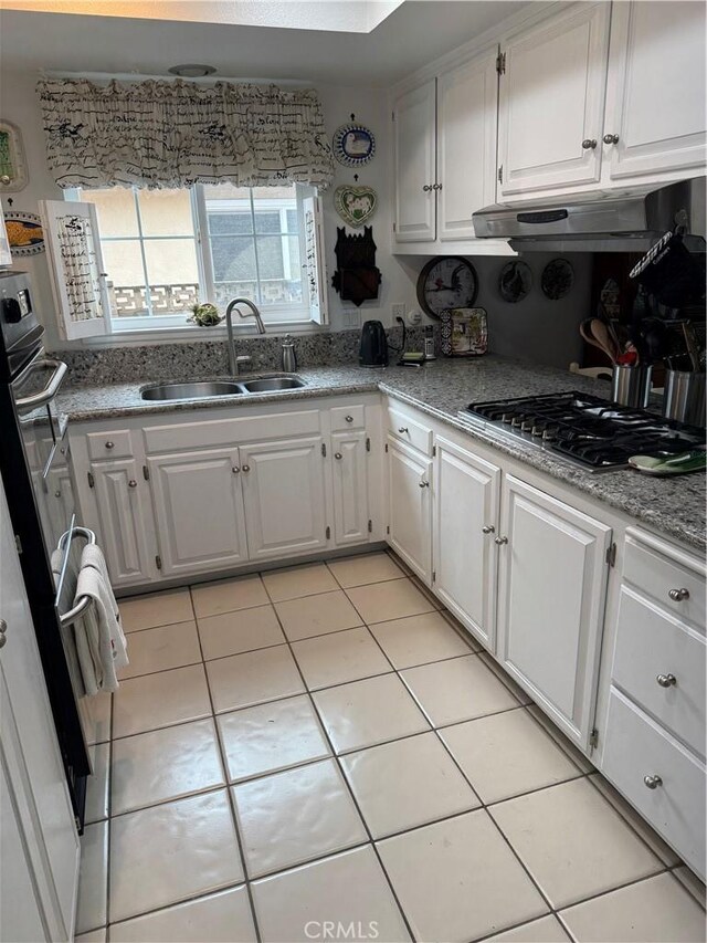 kitchen featuring stainless steel gas stovetop, white cabinetry, sink, light tile patterned floors, and light stone counters