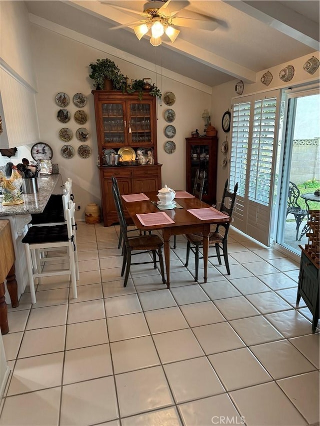 dining area featuring ceiling fan, light tile patterned floors, and vaulted ceiling with beams