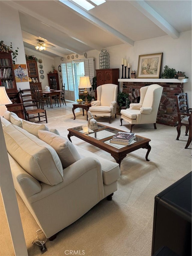 carpeted living room with ceiling fan, vaulted ceiling with beams, and a fireplace