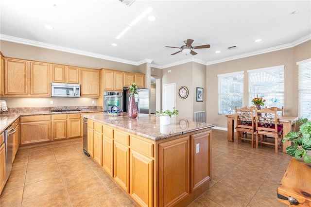 kitchen featuring light stone counters, a center island, light tile patterned floors, visible vents, and appliances with stainless steel finishes