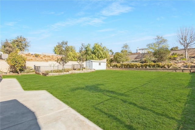 view of yard featuring fence private yard, a shed, and an outdoor structure