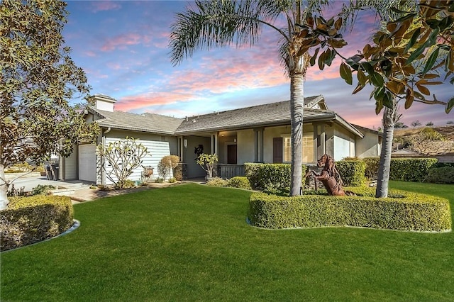 view of front of home featuring a garage and a yard