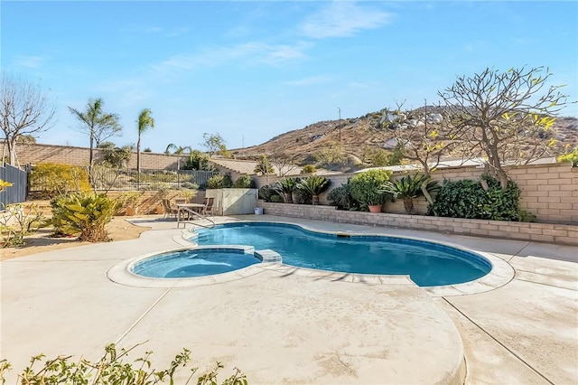 view of pool with a patio area, a fenced backyard, a fenced in pool, and an in ground hot tub