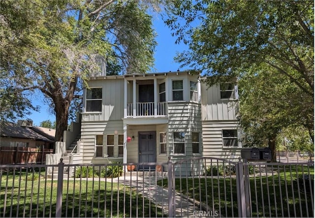 view of front facade with a front lawn and a balcony