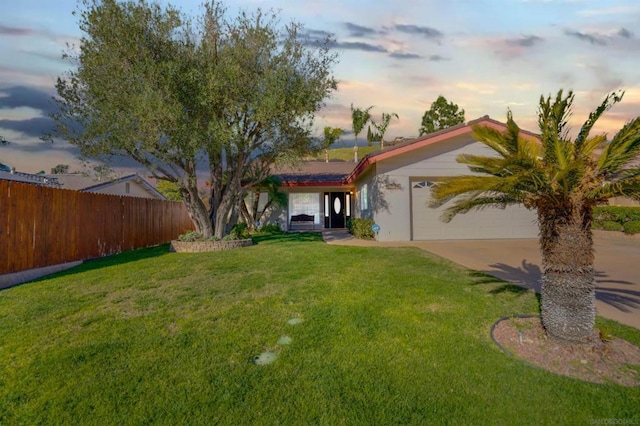 view of front of home with a garage and a lawn