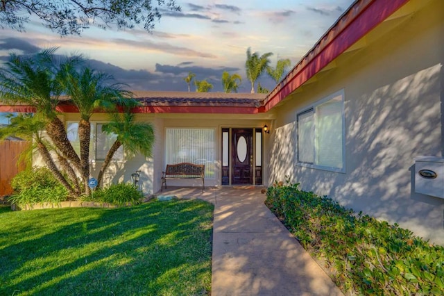 exterior entry at dusk with a yard