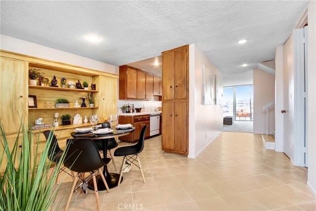 kitchen with light tile patterned flooring, dishwasher, and a textured ceiling