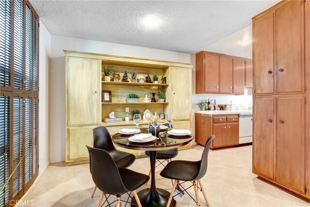 kitchen featuring white dishwasher and a textured ceiling