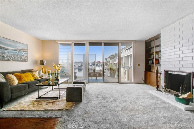 carpeted living room featuring a brick fireplace, a textured ceiling, floor to ceiling windows, and a healthy amount of sunlight