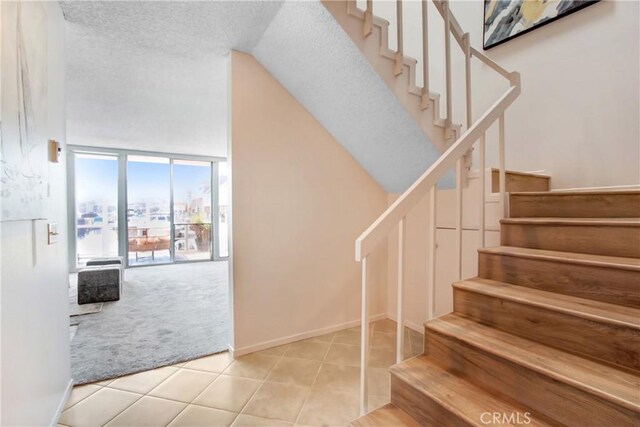 staircase featuring tile patterned flooring and a textured ceiling