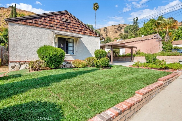 view of side of property with a mountain view and a yard