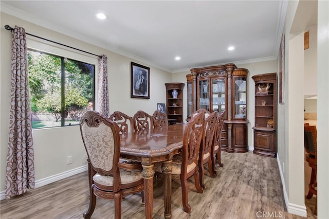 dining room with crown molding and light hardwood / wood-style floors