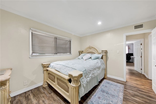 bedroom featuring crown molding and dark hardwood / wood-style floors