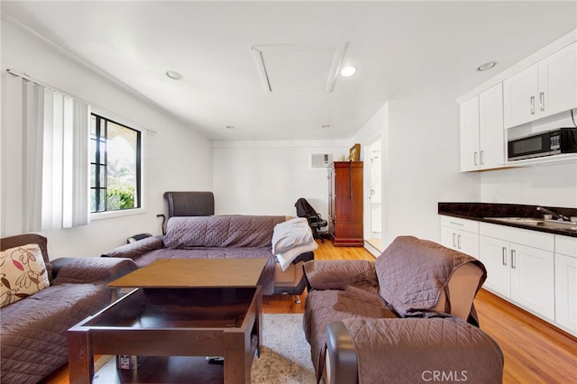 living room with sink and light wood-type flooring