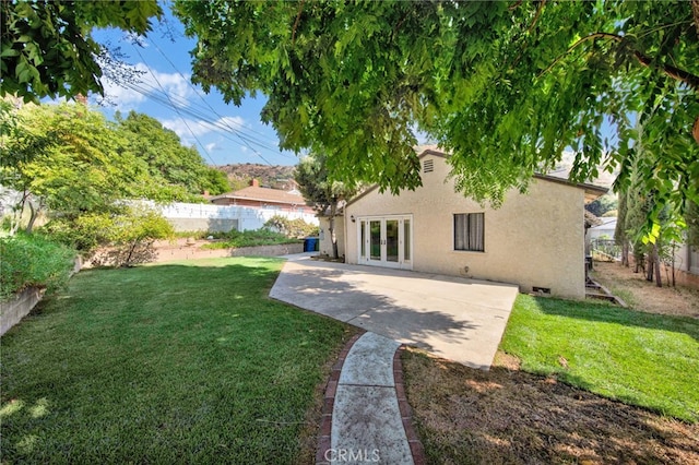 view of yard with french doors and a patio