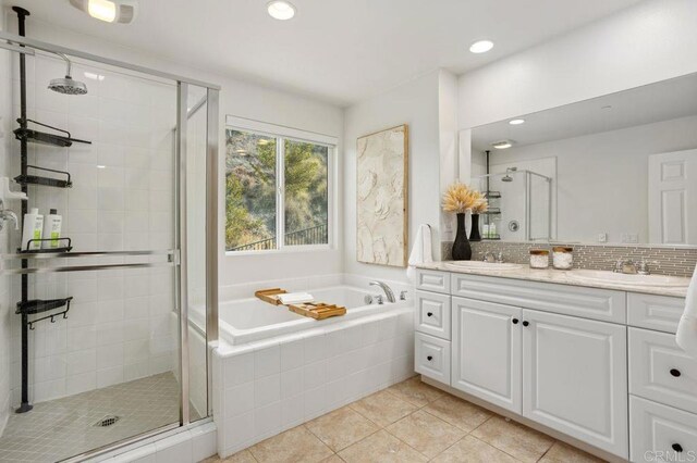 bathroom with decorative backsplash, vanity, tile patterned floors, and plus walk in shower