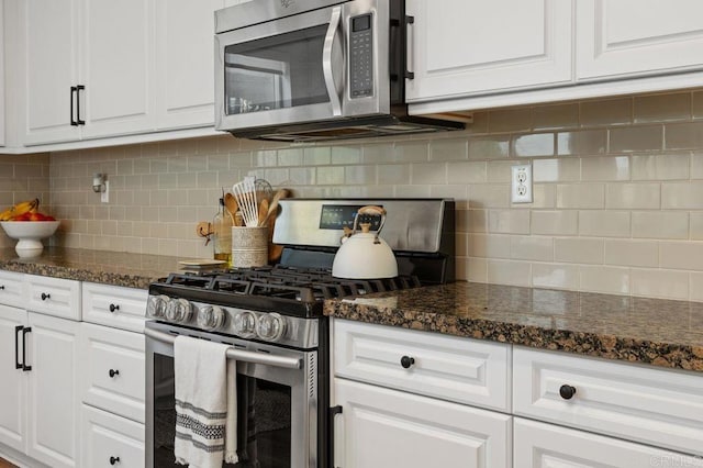 kitchen with dark stone countertops, backsplash, stainless steel appliances, and white cabinets