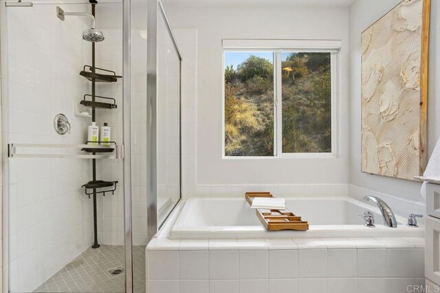 bathroom featuring independent shower and bath