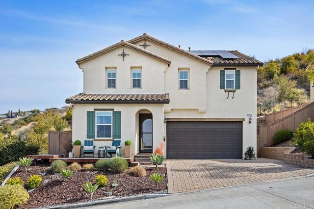 mediterranean / spanish home with a garage and solar panels