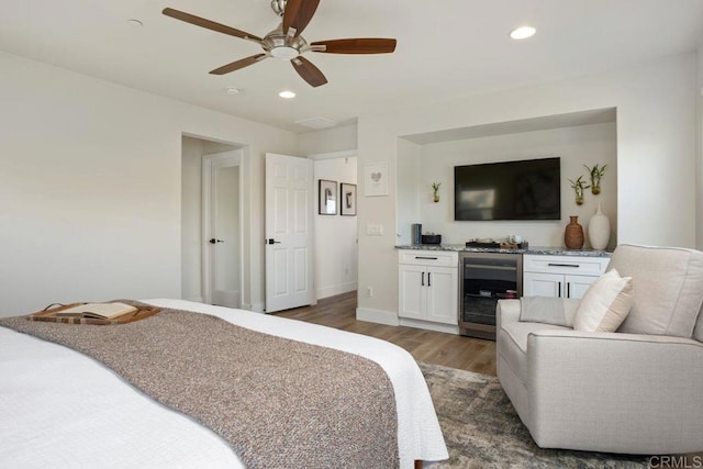 bedroom with wine cooler, dark hardwood / wood-style flooring, and ceiling fan