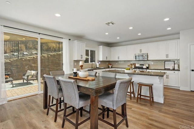 dining room featuring sink and light wood-type flooring