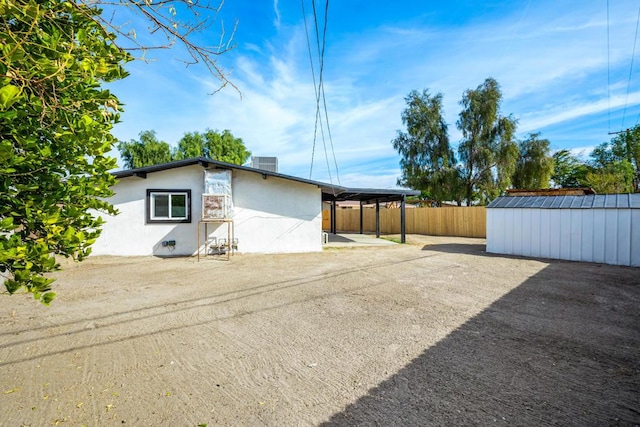 exterior space featuring cooling unit, a carport, and a storage unit