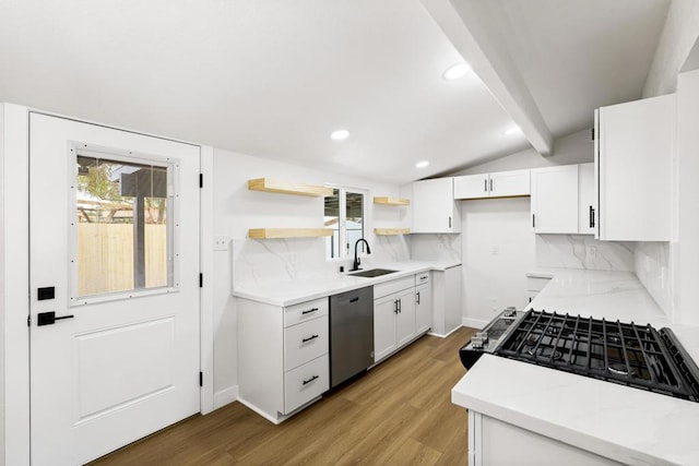 kitchen featuring white cabinetry, appliances with stainless steel finishes, sink, and lofted ceiling with beams